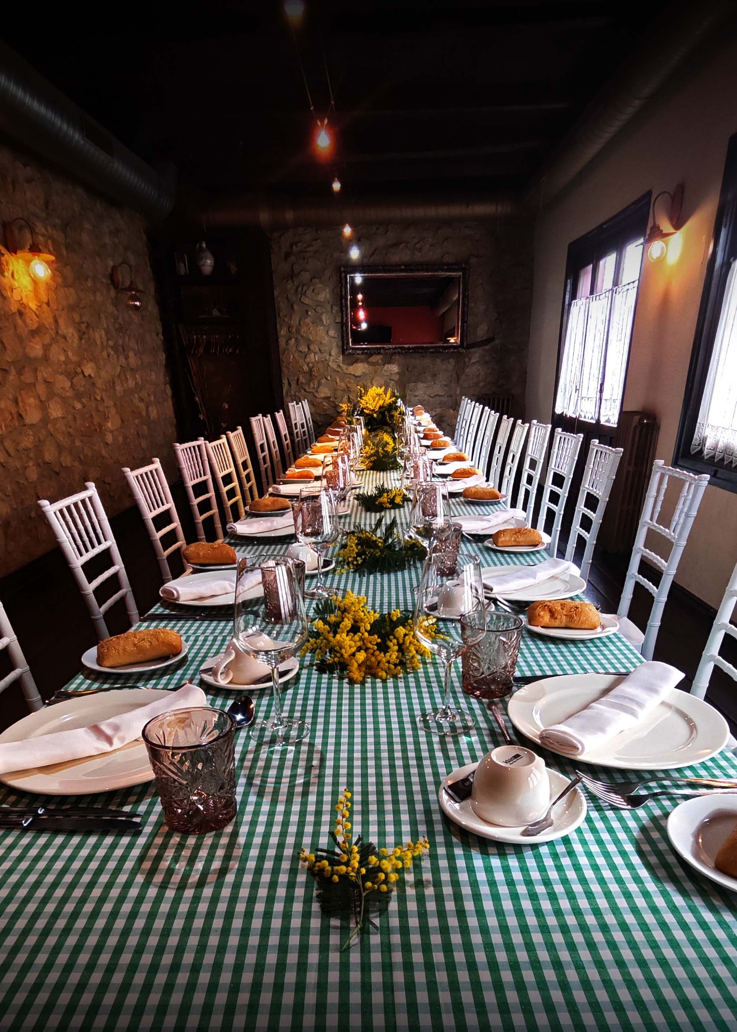 Mesa larga para celebraciones con mantel de cuadros verdes y blancos